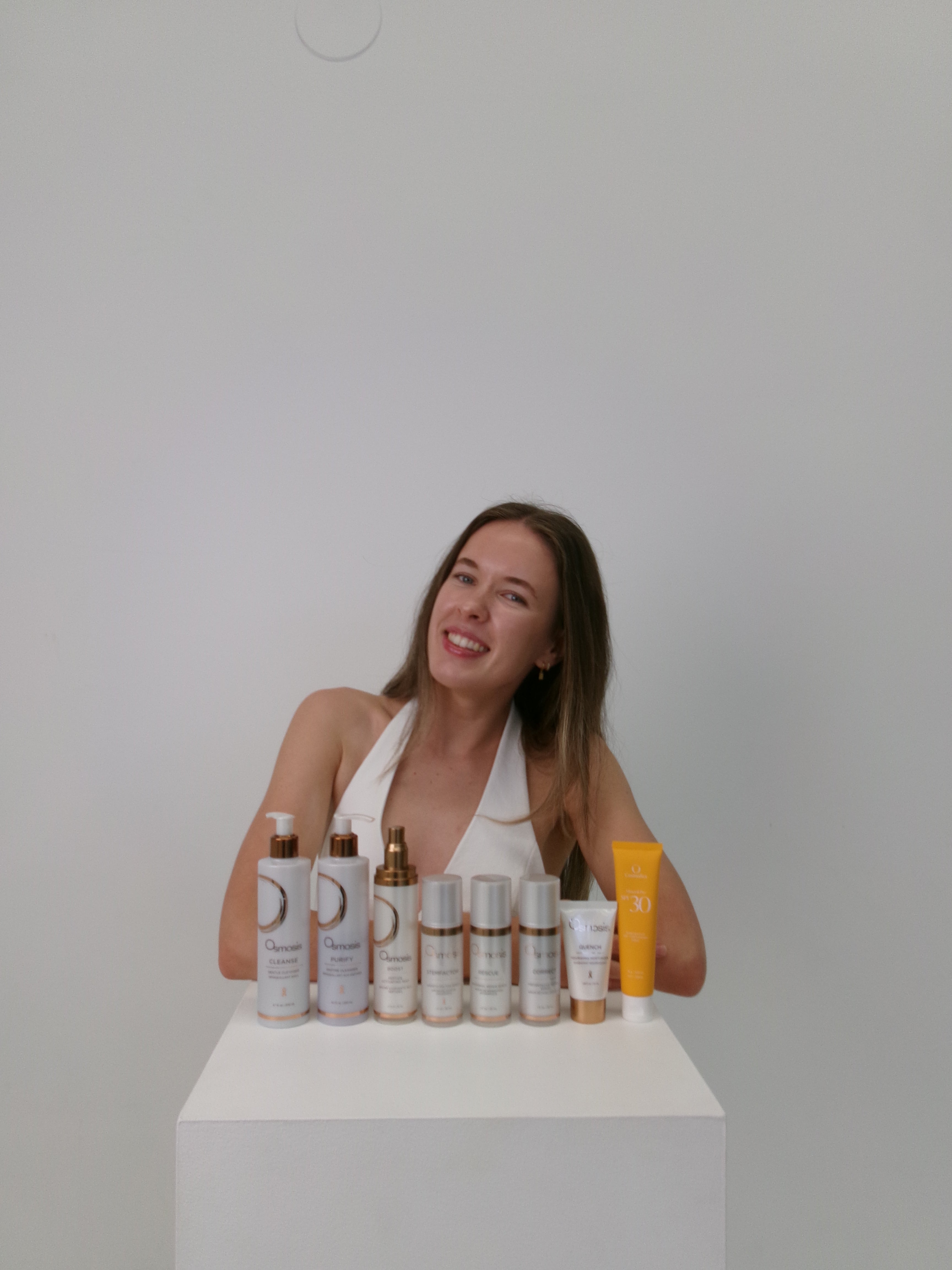 Dermal therapist standing beside professional skincare products at The Skin Suite Collective in The Vines, WA